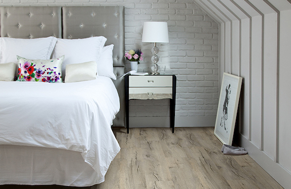 warm, rustic luxury vinyl plank flooring in a cozy bedroom